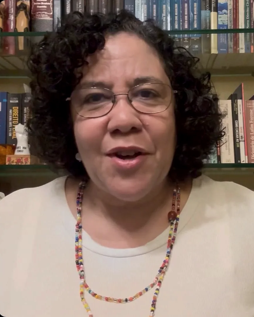 Vanilda de Carvalho gravando seu depoimento em frente à estante de livros